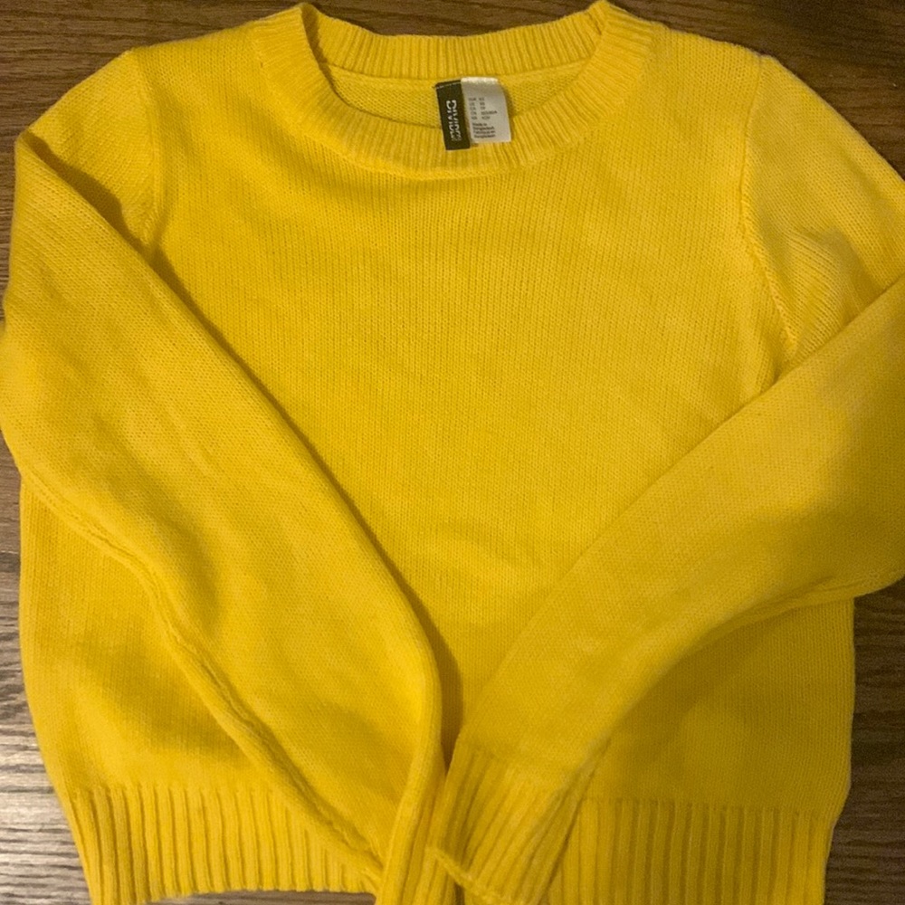 I am selling, a yellow knit sweater. It has never been worn.